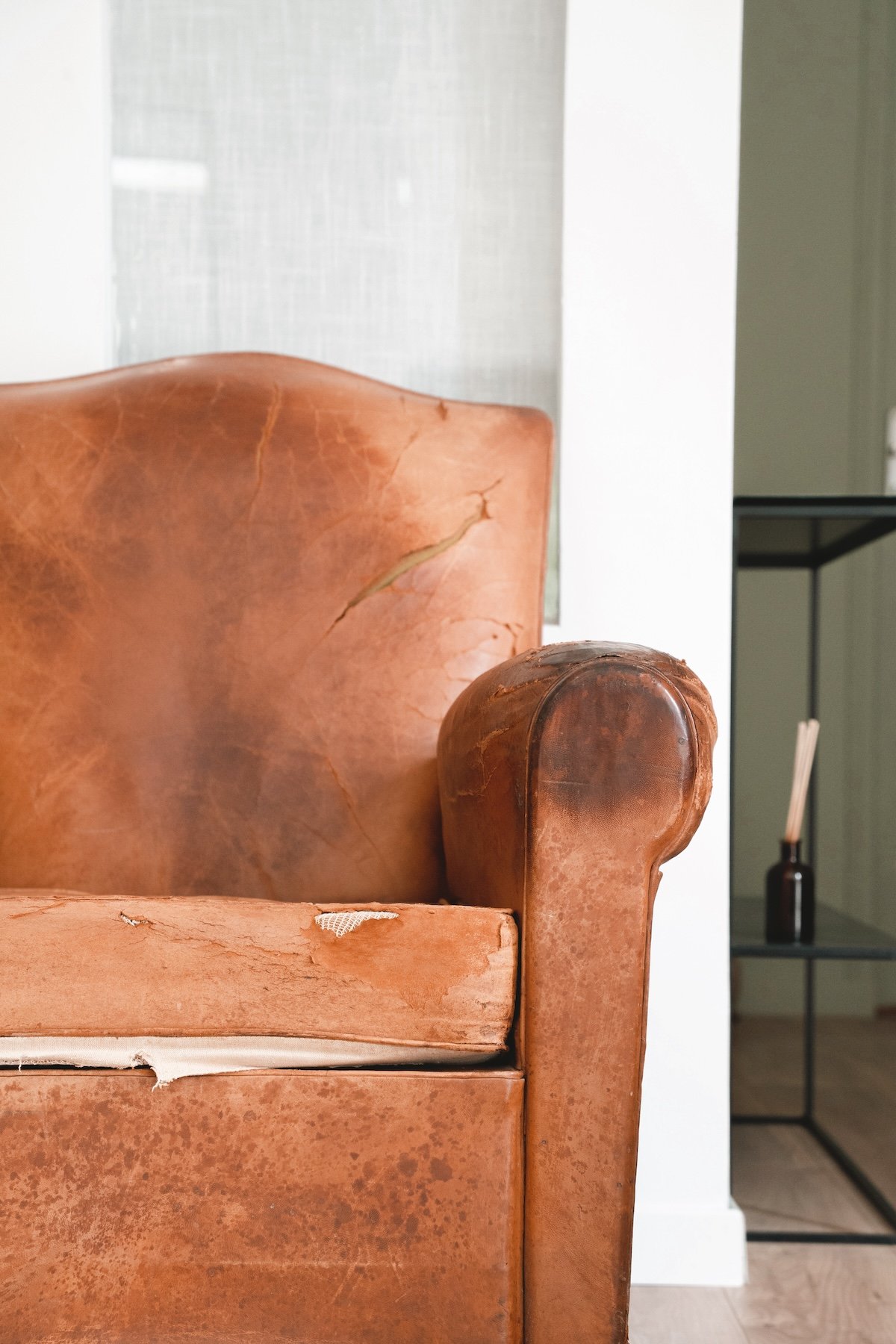 Fauteuil ancien en attente de rénovation dans l'atelier de Mélina Wathelet, tapissier décorateur à Guidel